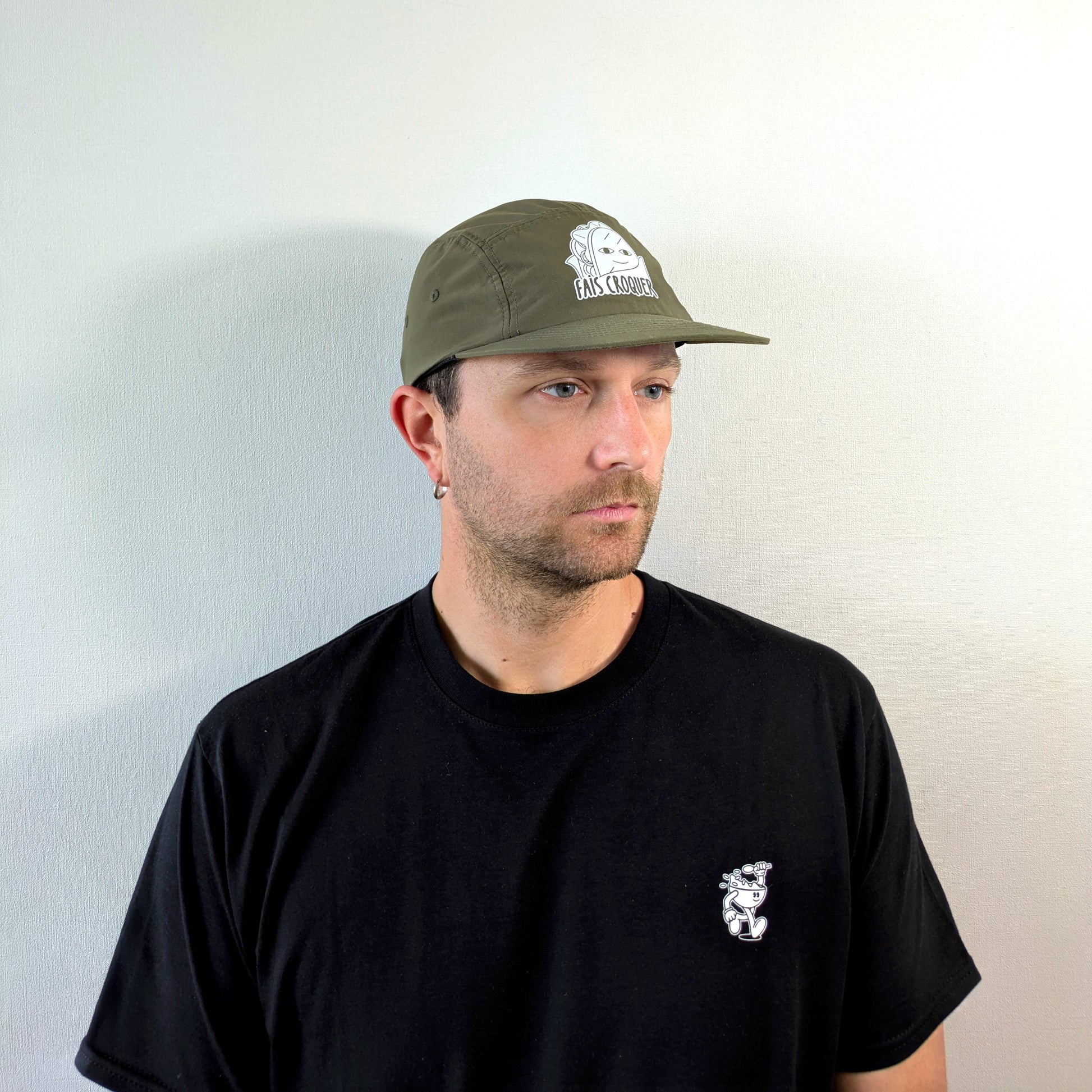 Vue de trois quarts d’un homme portant la casquette verte Fais Croquer, visuel clair du logo et de la coupe