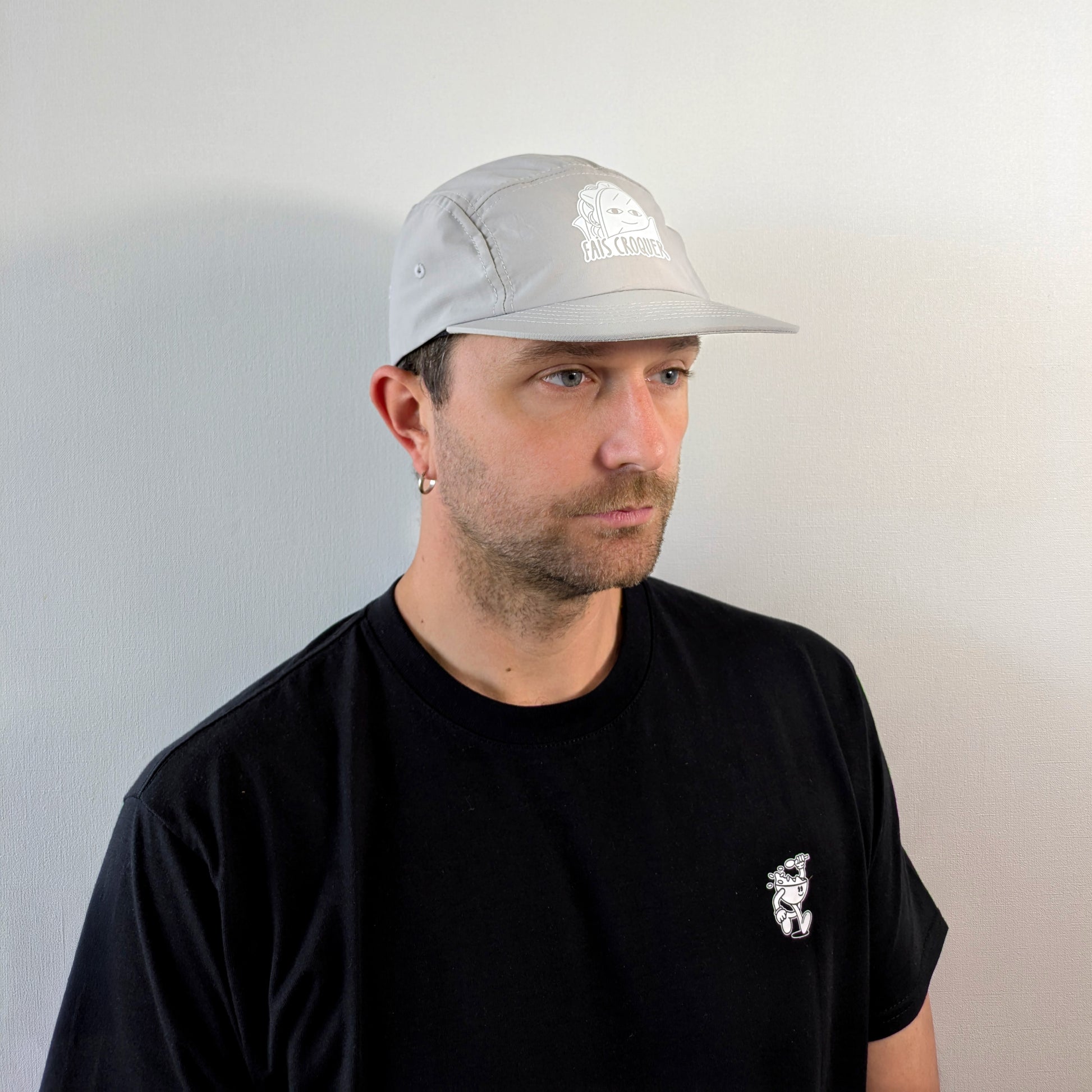Vue de trois quarts d’un homme portant la casquette beige Fais Croquer, style simple et graphique